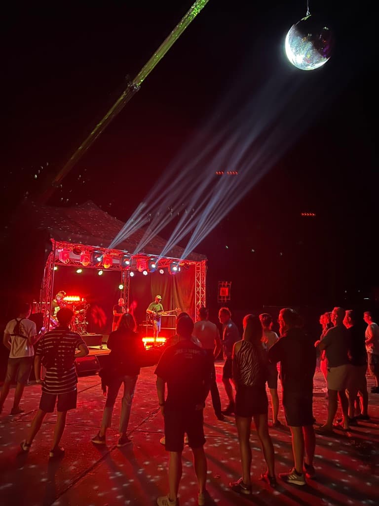 Audience in front of the stage with disco ball on crane